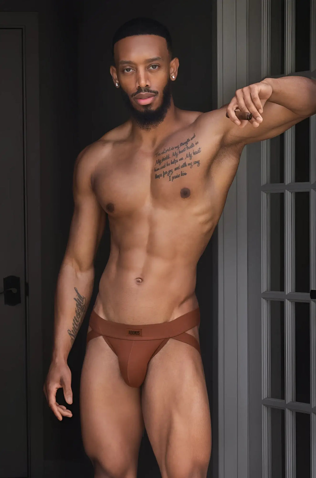 Brown sugar jockstrap in brown briefs with a subtle logo on the waistband showing the front side