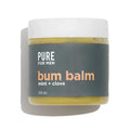 A matte white jar of pure for men bum balm with a dark gray label and yellowish green mint and clove balm