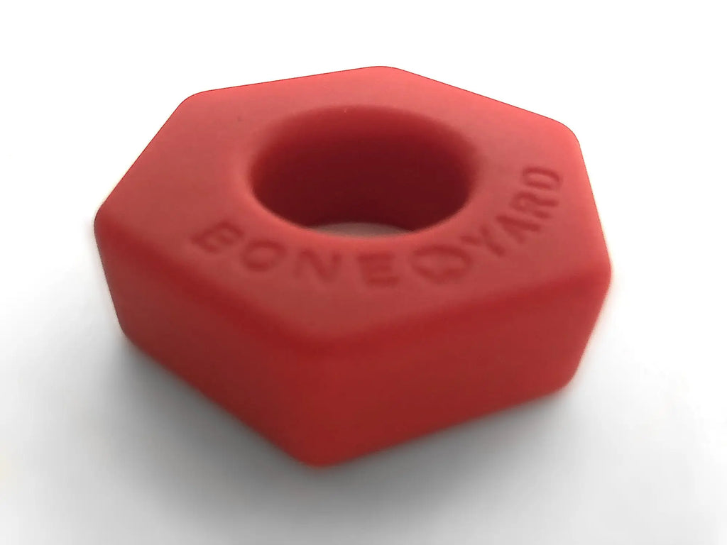 Red hexagonal silicone nut-shaped toy embossed with boneyard in the bust a nut red collection