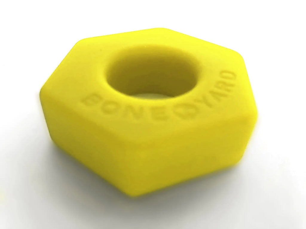 Bright yellow hexagonal silicone nut embossed with boneyard for skate tool use in bust a nut yellow series