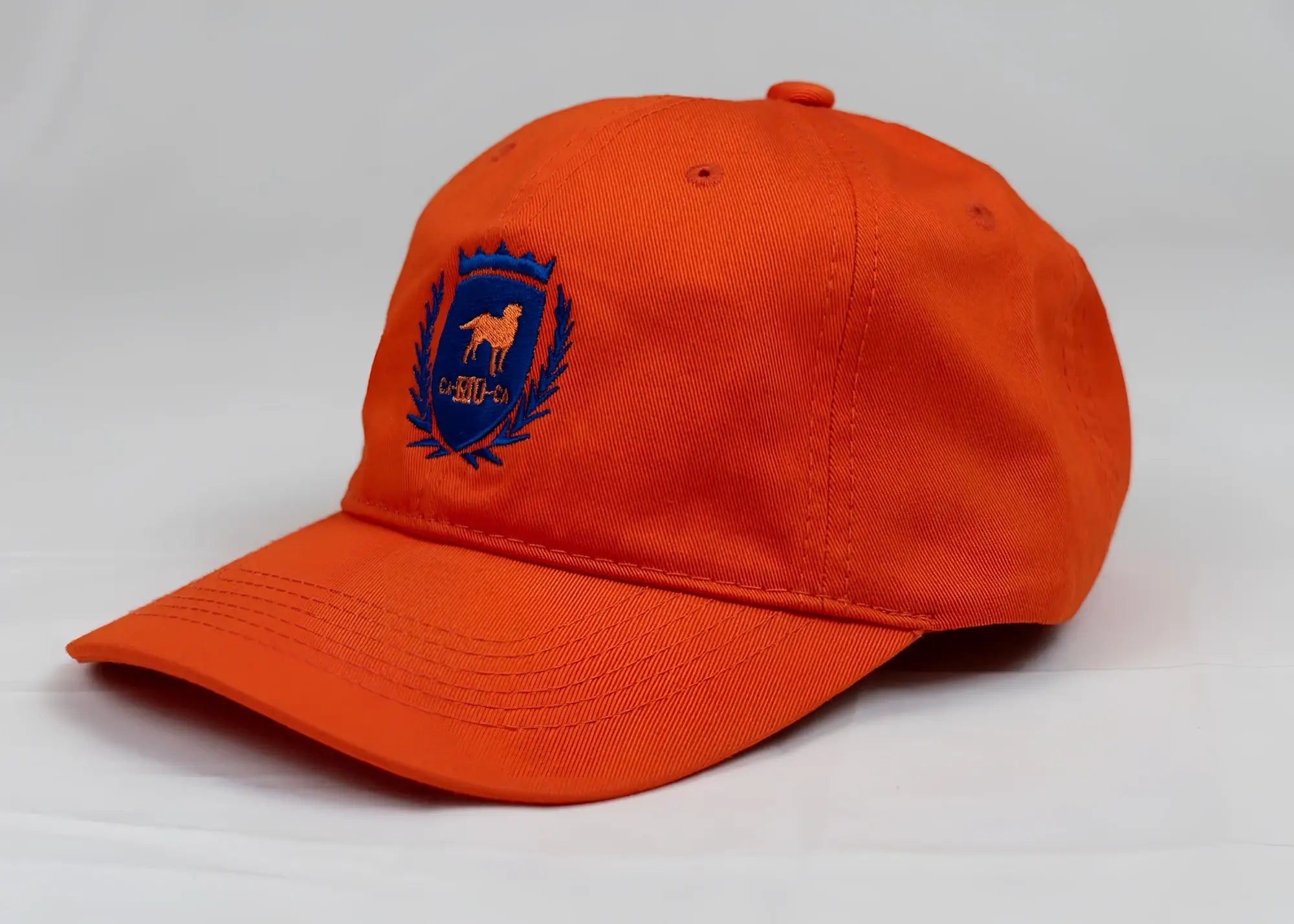 Bright orange CA-RIO-CA men’s baseball cap with blue embroidered horse and laurel wreath crest design