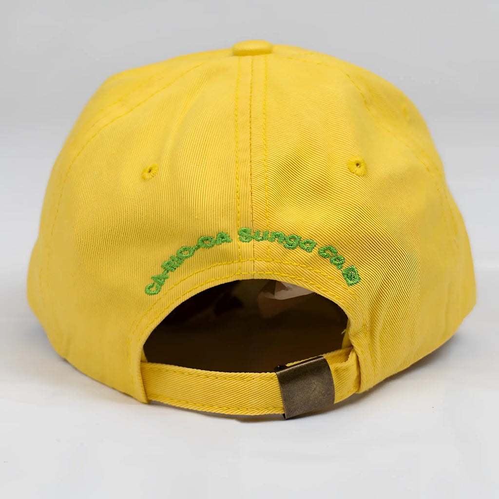 Back side of bright yellow ca-rio-ca crest logo embroidered designer dad hat with green text and metallic strap