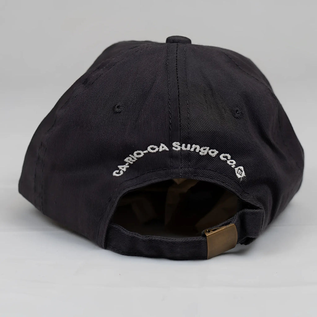 Black cotton ca-rio-ca crest logo embroidered designer dad hat with white text and brass adjustable strap showing back side