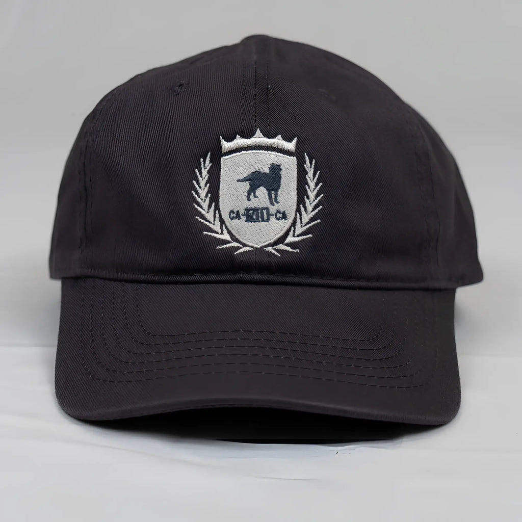 Black cotton dad hat with white embroidered CA-RIO-CA shield emblem featuring black dog and laurel wreath details