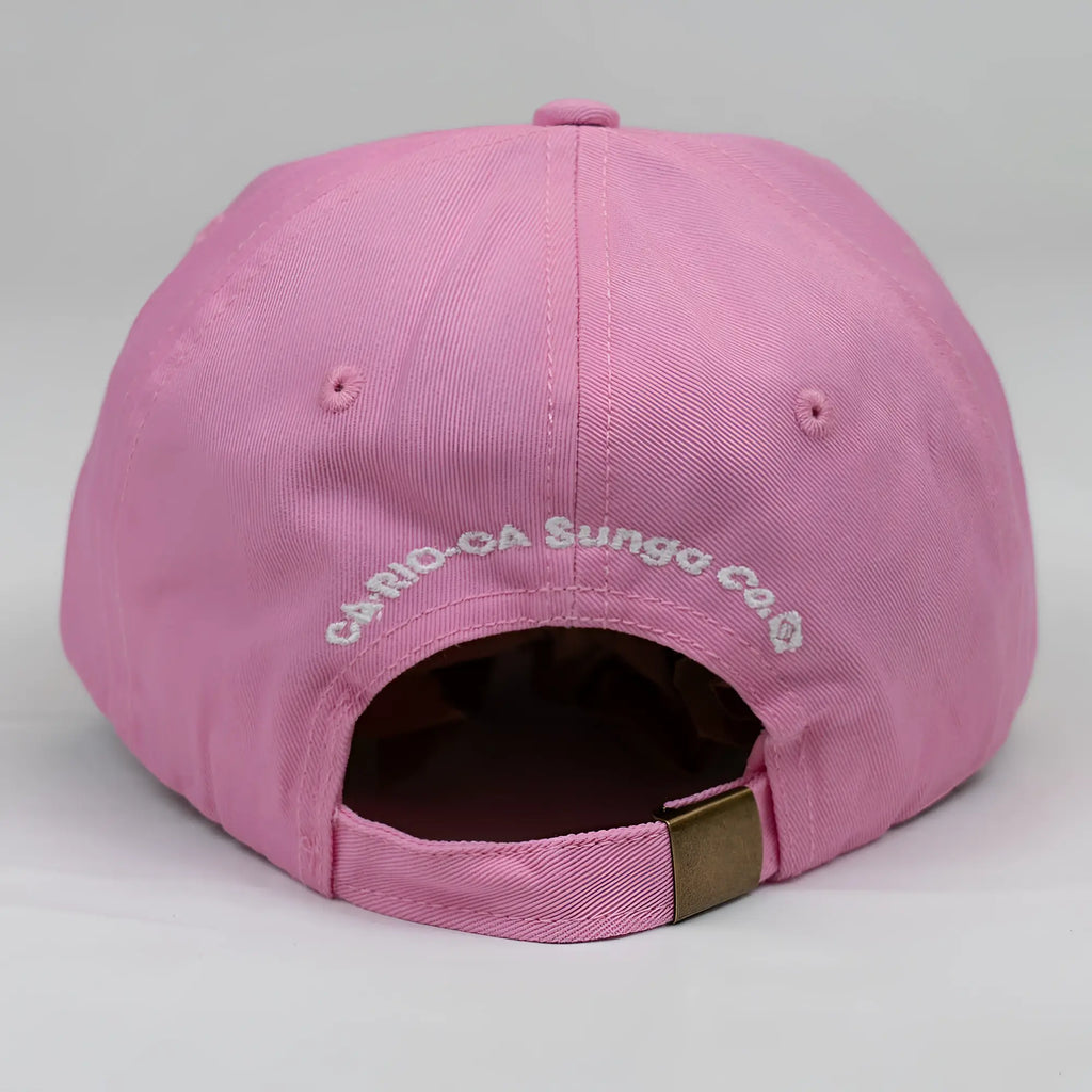 Pink cotton ca-rio-ca crest logo embroidered dad hat with white text and brass metal adjustment strap back side view