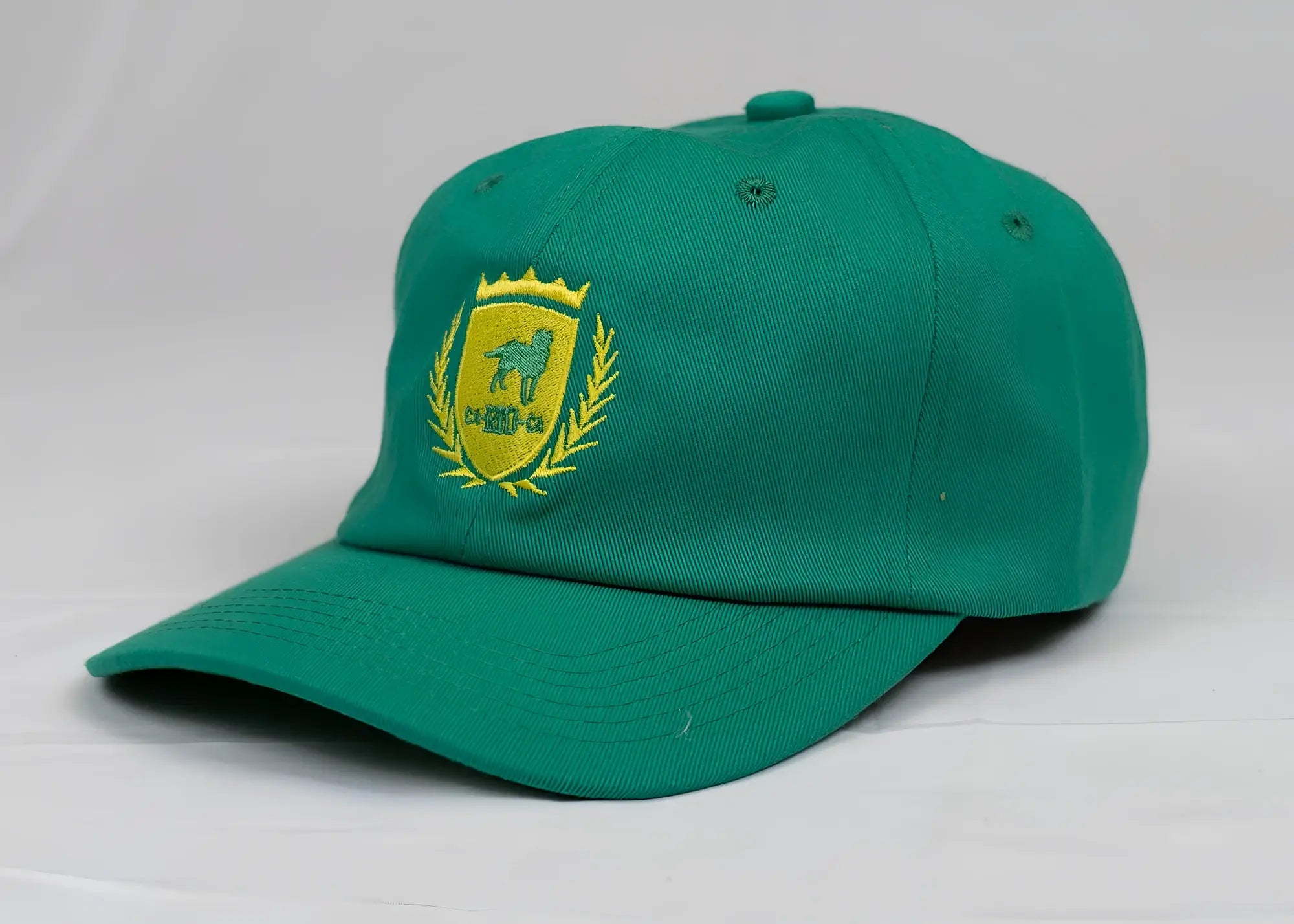 Green ca-rio-ca dad hat featuring a yellow embroidered horse and laurel crest designed for men