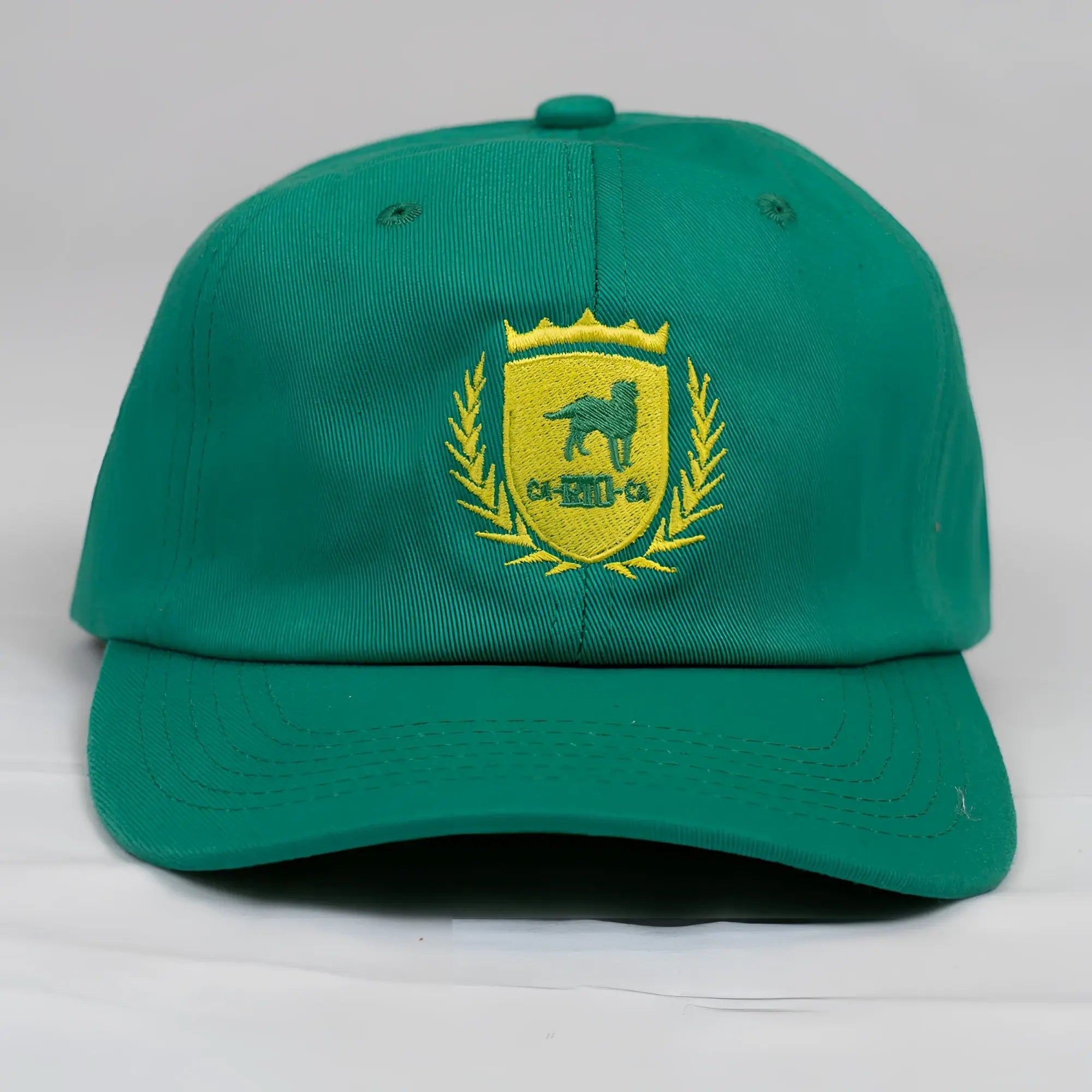 A vibrant green ca-rio-ca designer dad hat with a yellow embroidered dog crest and laurel wreath men’s baseball cap