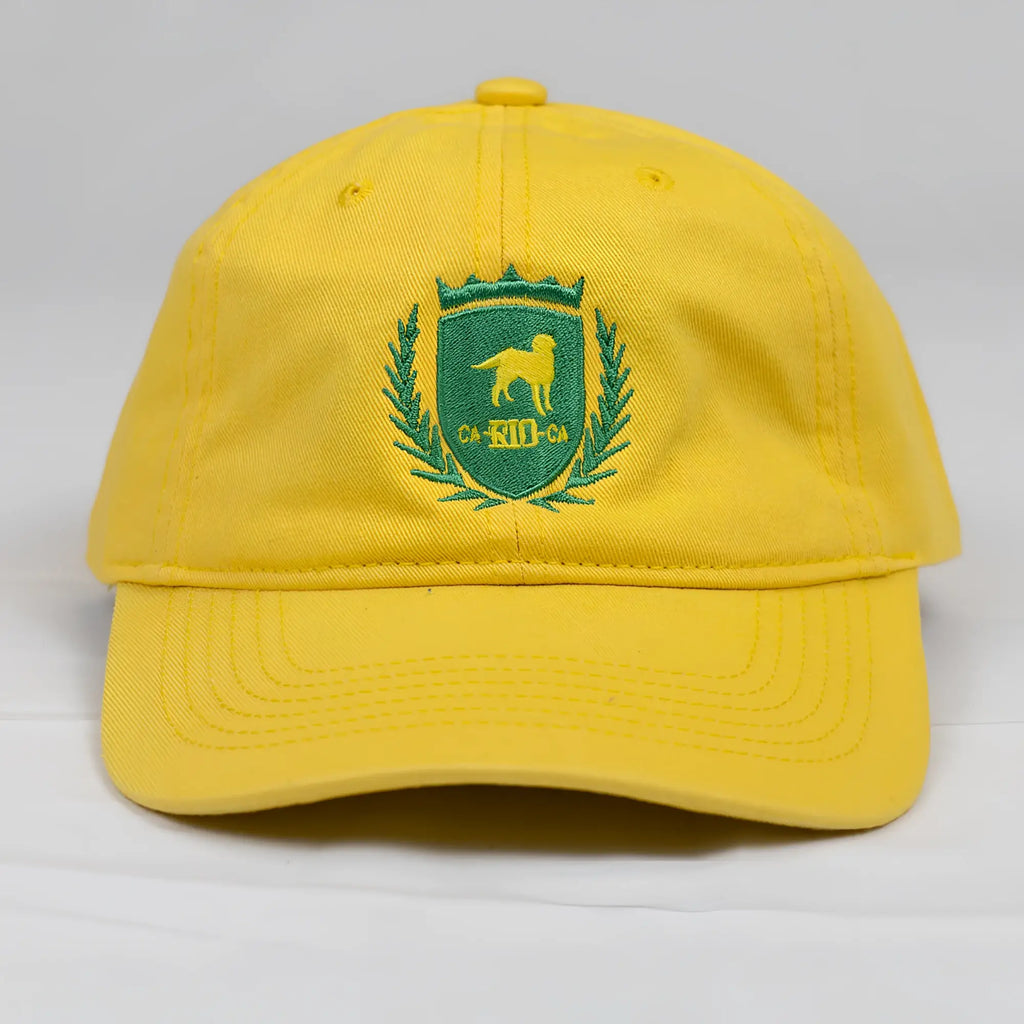 Bright yellow CA-RIO-CA designer dad hat featuring green embroidered dog crest and laurel wreath logo