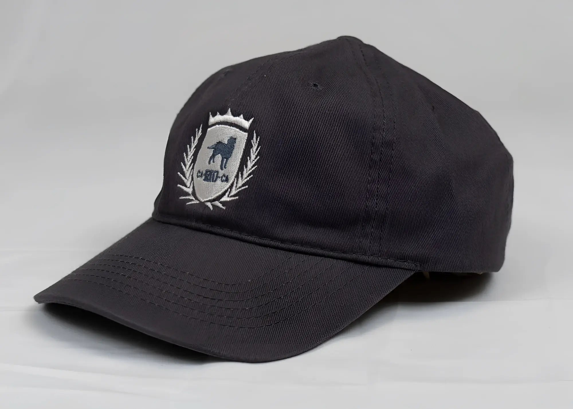 Dark gray CA-RIO-CA crest logo embroidered designer dad hat with dog silhouette laurel wreath and crown emblem