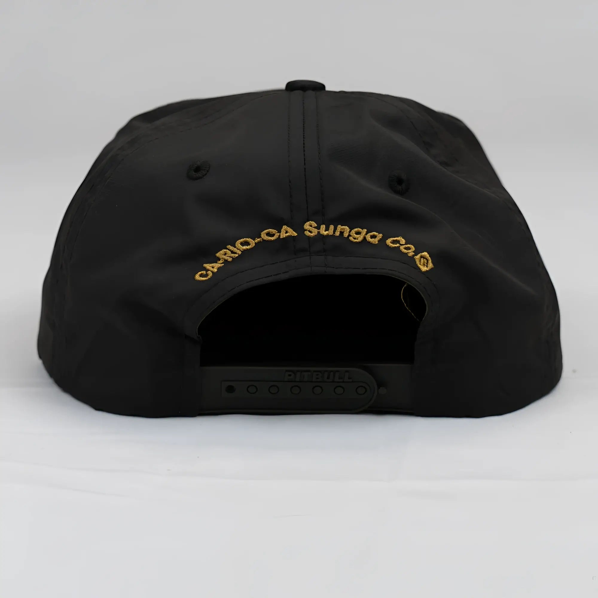 Black unstructured bay leaf snapback rope hat showing back side with gold embroidered cario-ca sunga co text