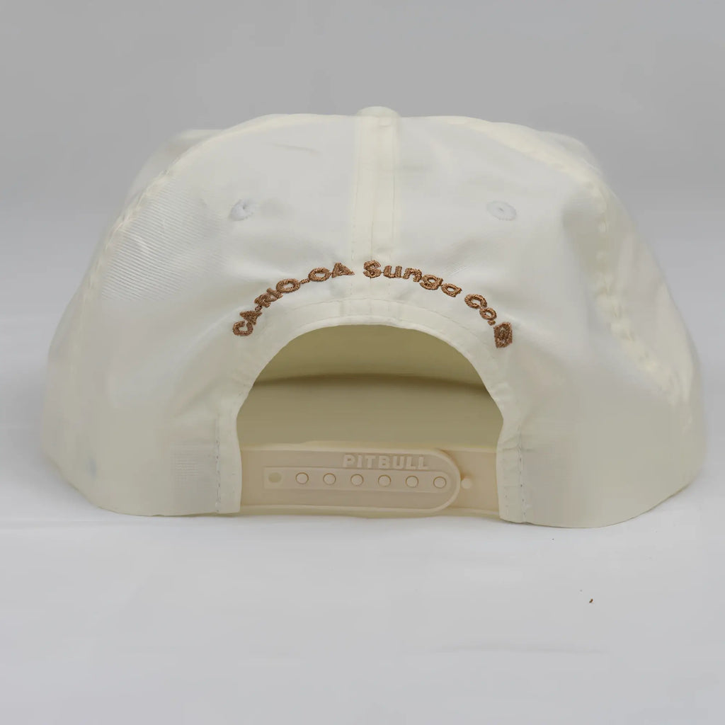 Cream-colored unstructured bay leaf snapback rope hat with brown embroidered crest logo and plastic adjustable strap