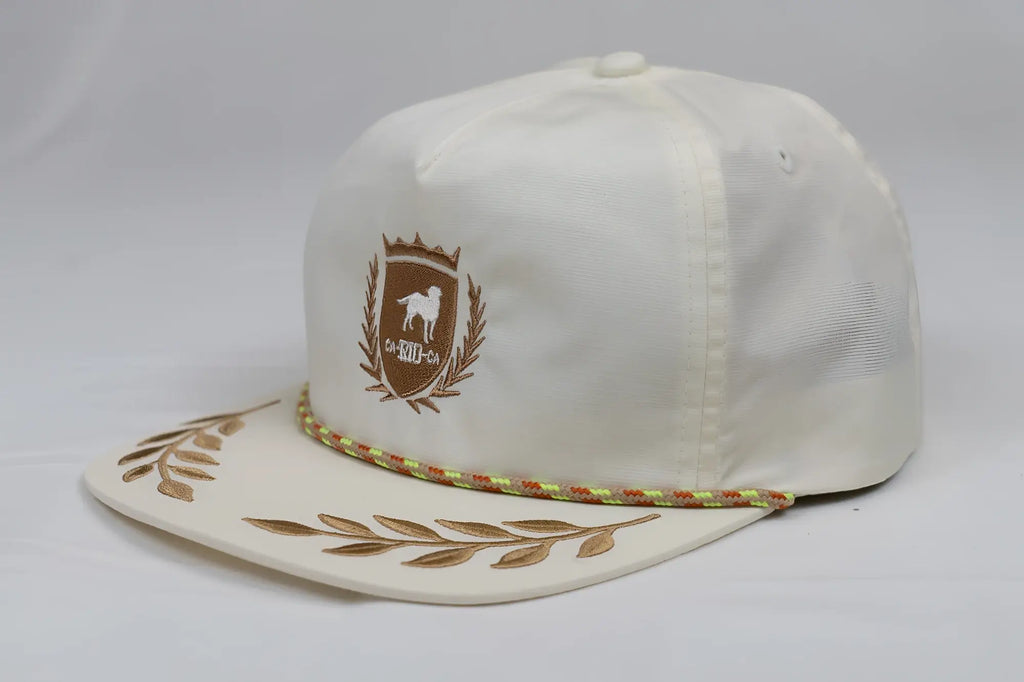 Cream-colored unstructured bay leaf snapback rope hat with brown embroidered dog crest and gold leaf brim accents