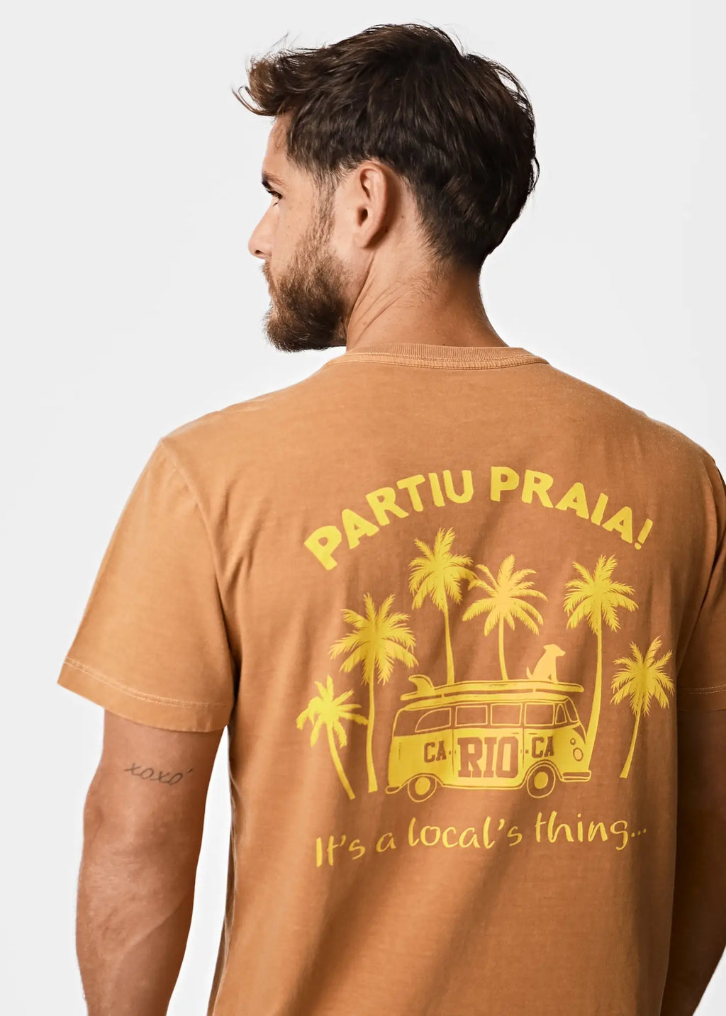A tan cotton men’s t-shirt featuring a yellow palm tree and vintage van graphic with partiu praia text