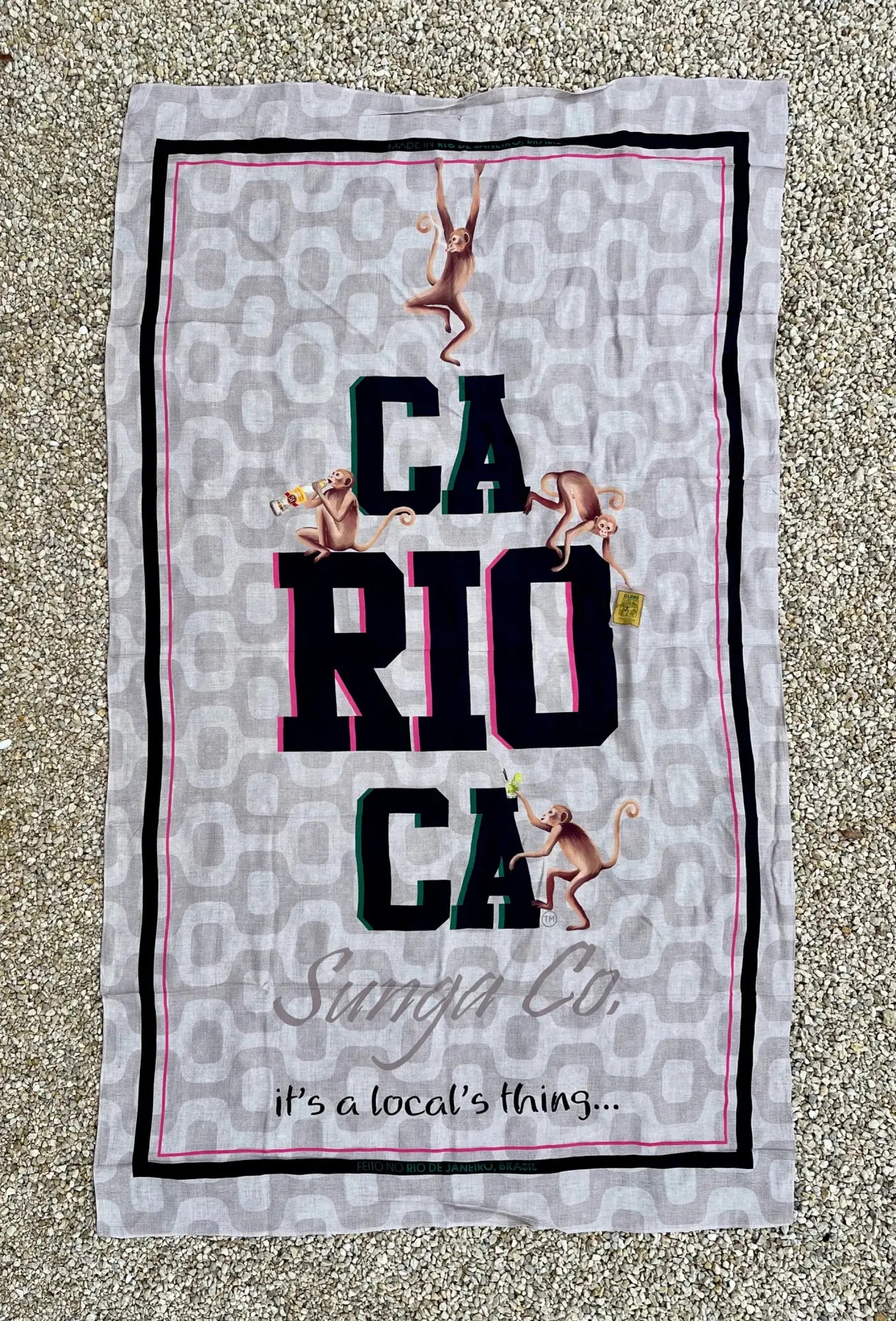 Gray brazilian beach towel with leopard print background black and pink trim featuring carioca text and monkeys