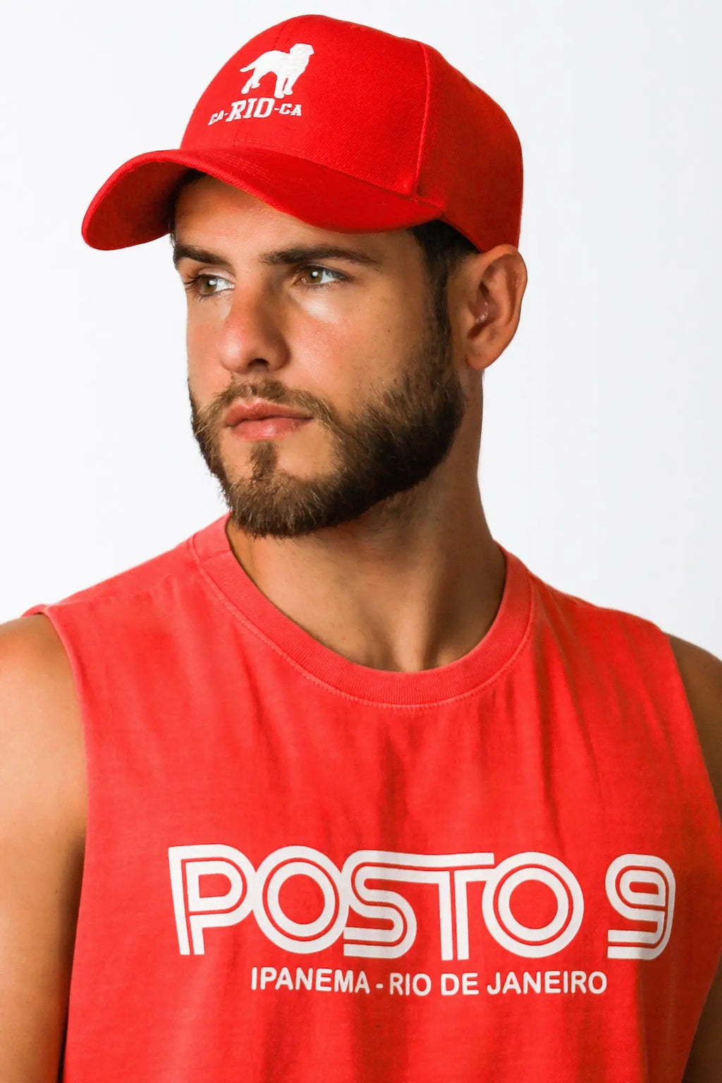 Red baseball hat featuring a white lion silhouette and ca rio ca text embroidered on the front for casual wear