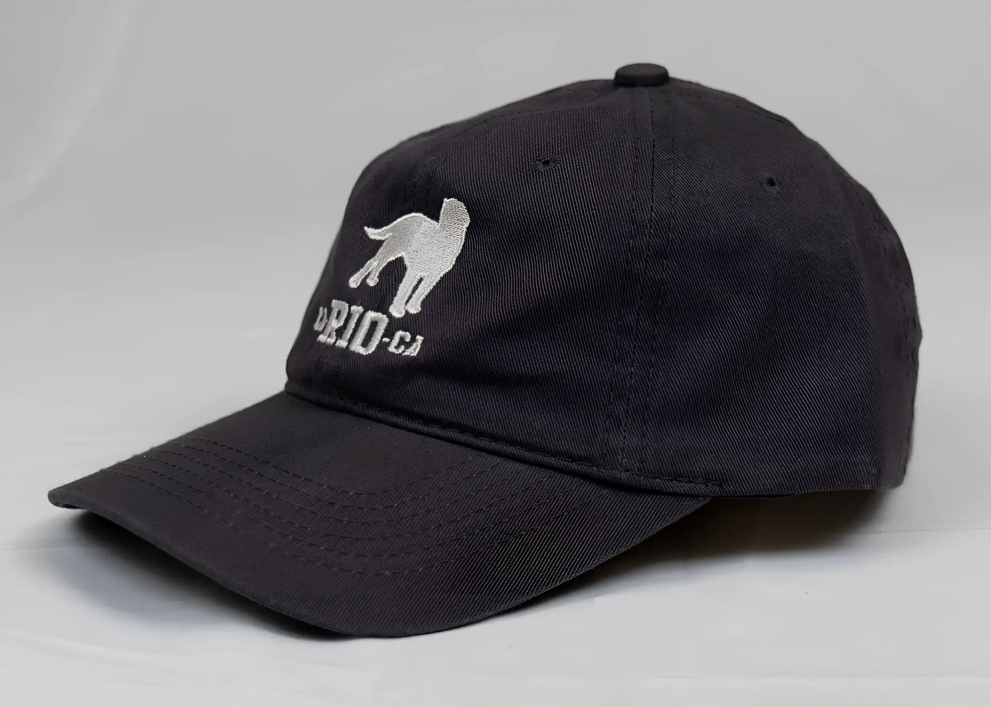 Black men’s baseball cap with silver embroidered dog silhouette and briid ca text in ca-rio-ca logo design