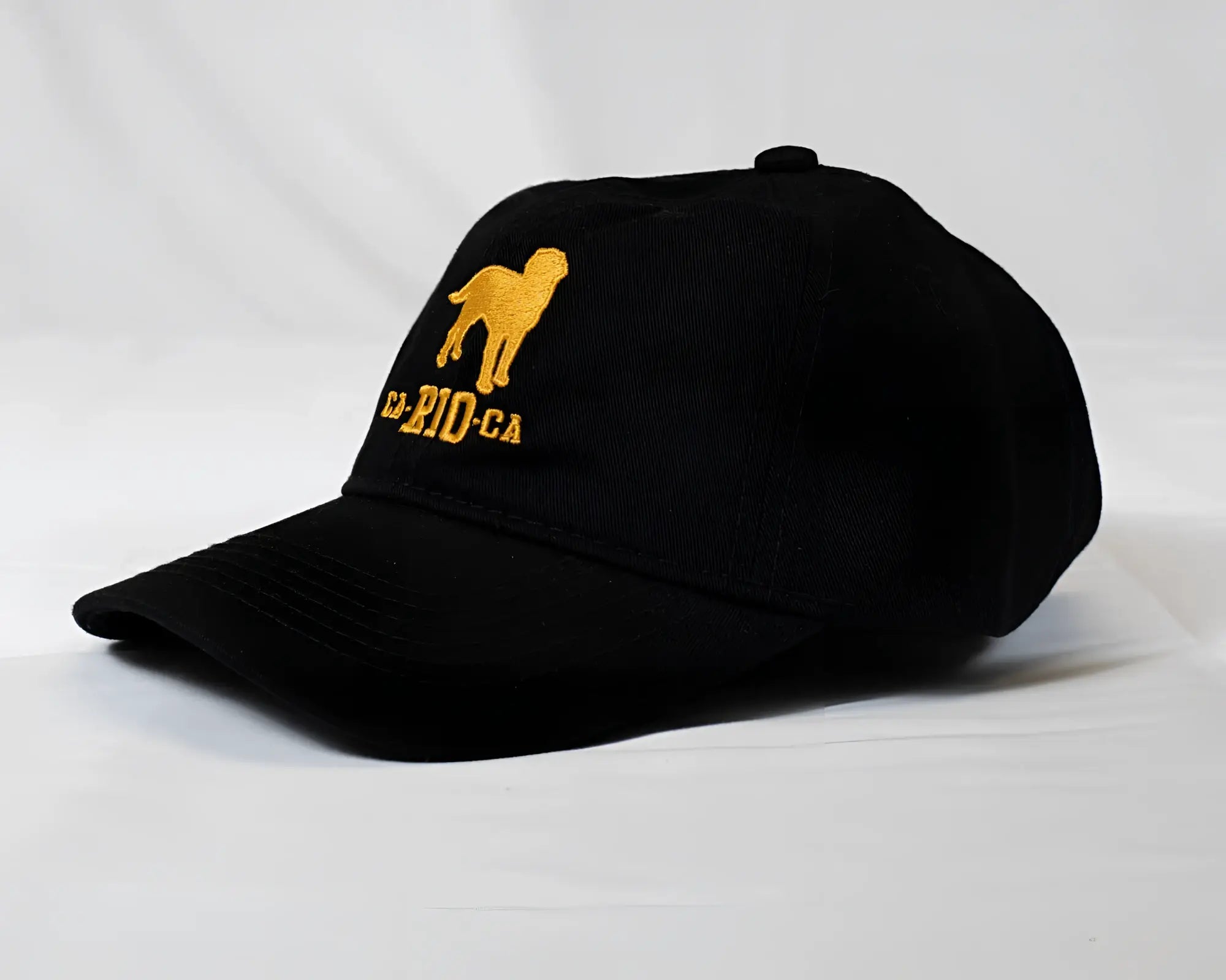 Black baseball cap with gold embroidered dog silhouette and ca-rio-ca logo designed for men’s casual wear