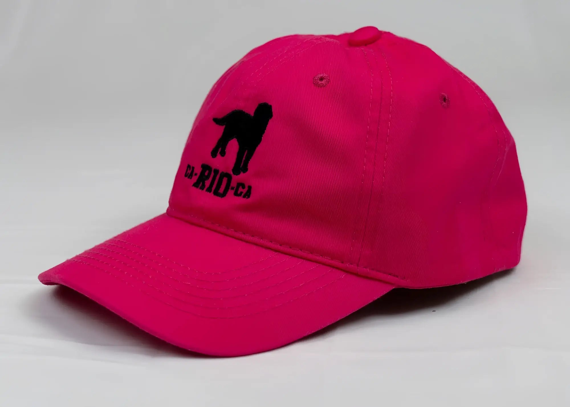 Vibrant pink ca-rio-ca logo embroidered designer dad hat featuring black dog silhouette men’s baseball cap