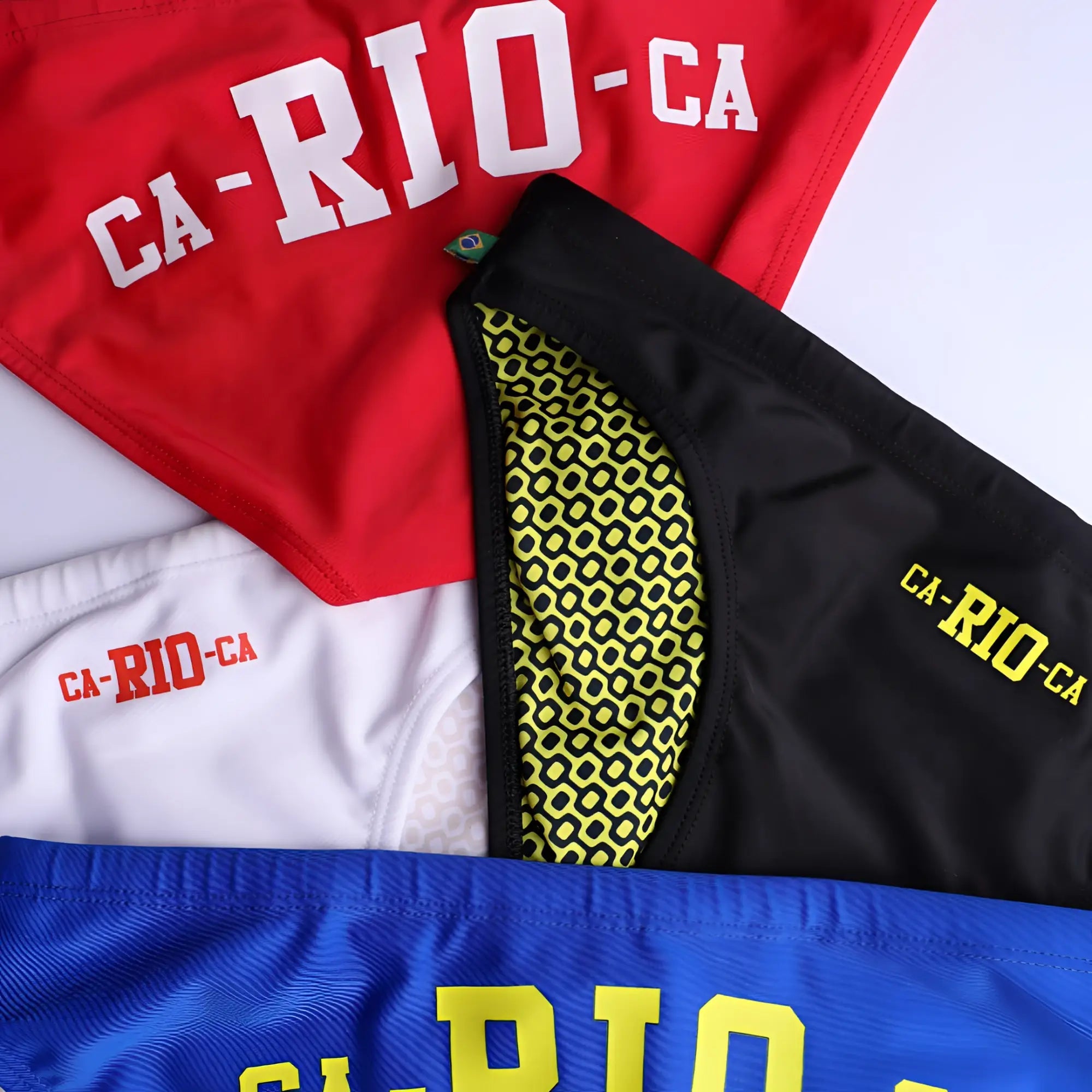 Black men’s swimming sunga with neon yellow geometric lining and bright yellow ca-rio-ca logo embroidery for beachwear