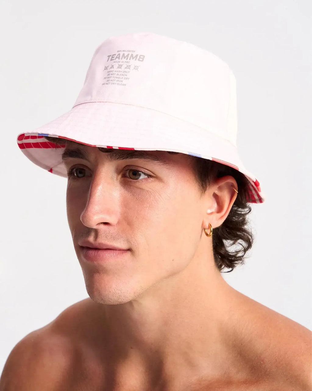 White cabana bucket hat with red and blue striped brim featuring teammb branding in cotton material