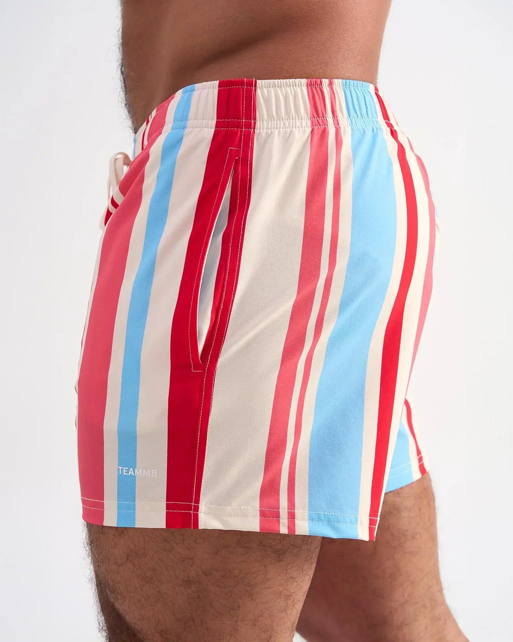 Cabana swim short featuring red light blue and cream vertical stripes with a side pocket and elastic waistband