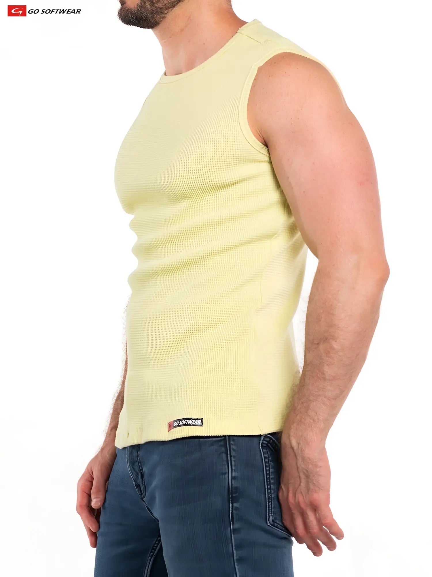 A pale yellow ribbed knit sleeveless tank top with a small black and red brand tag at the bottom hem