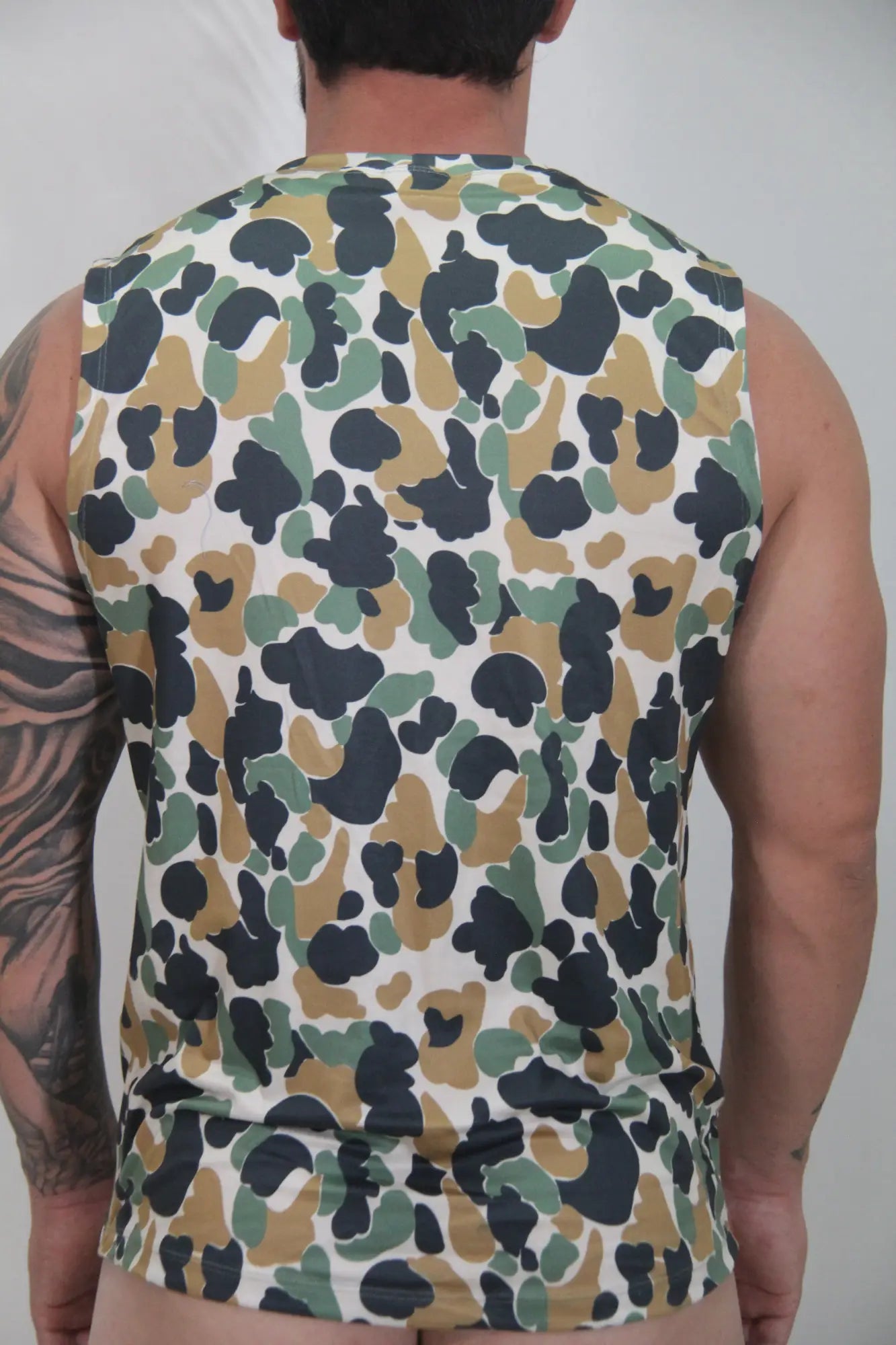 Camouflage open arm tank sleeveless top with olive green tan and black splotches on white base for casual wear