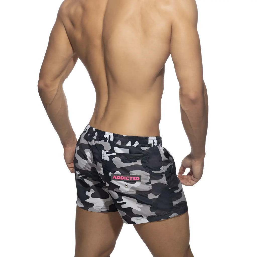 Back side of black and gray camouflage swim short with pink addicted logo patch on back pocket