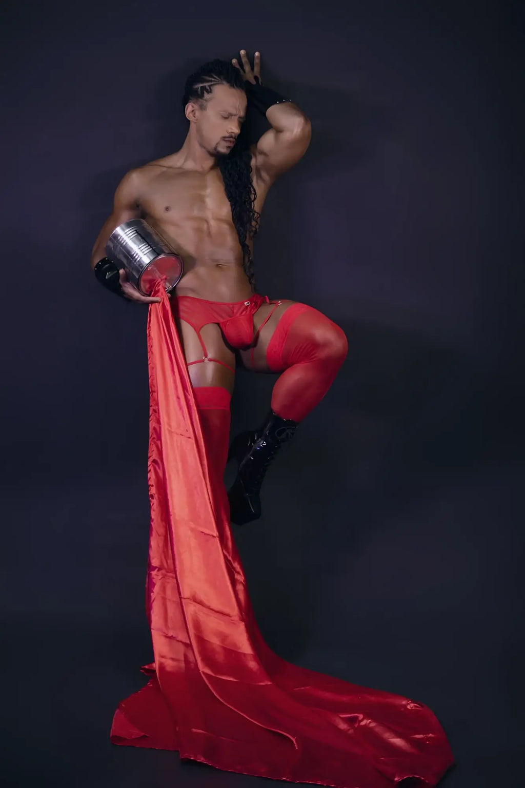 Shiny red satin fabric flowing from a man’s leg wearing candyman 99792 mesh garter thongs in red back view