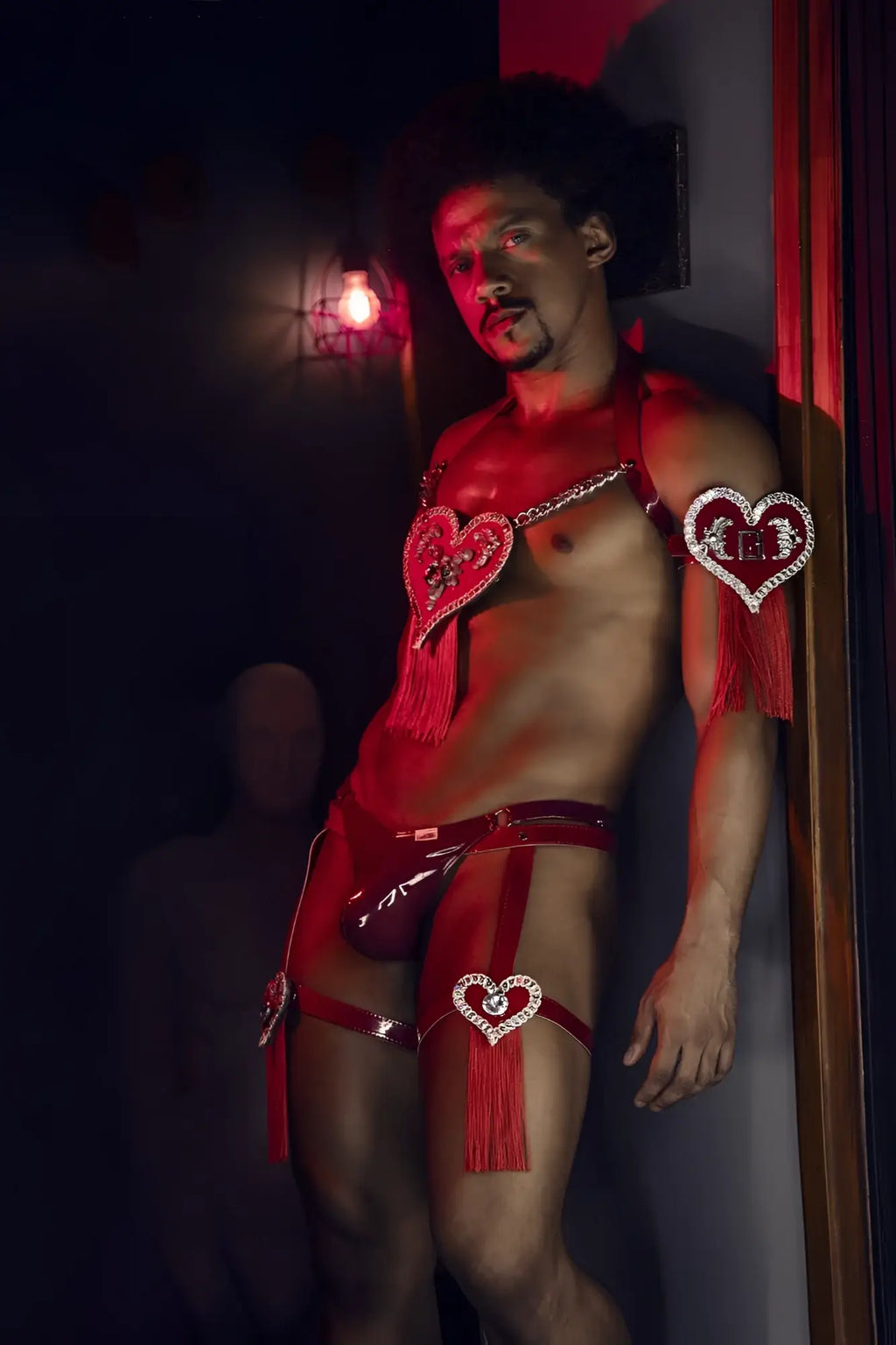 Red heart-shaped rhinestone embellishments and tassels adorn a shiny wine gloss latex CandyMan 99819 dom thong