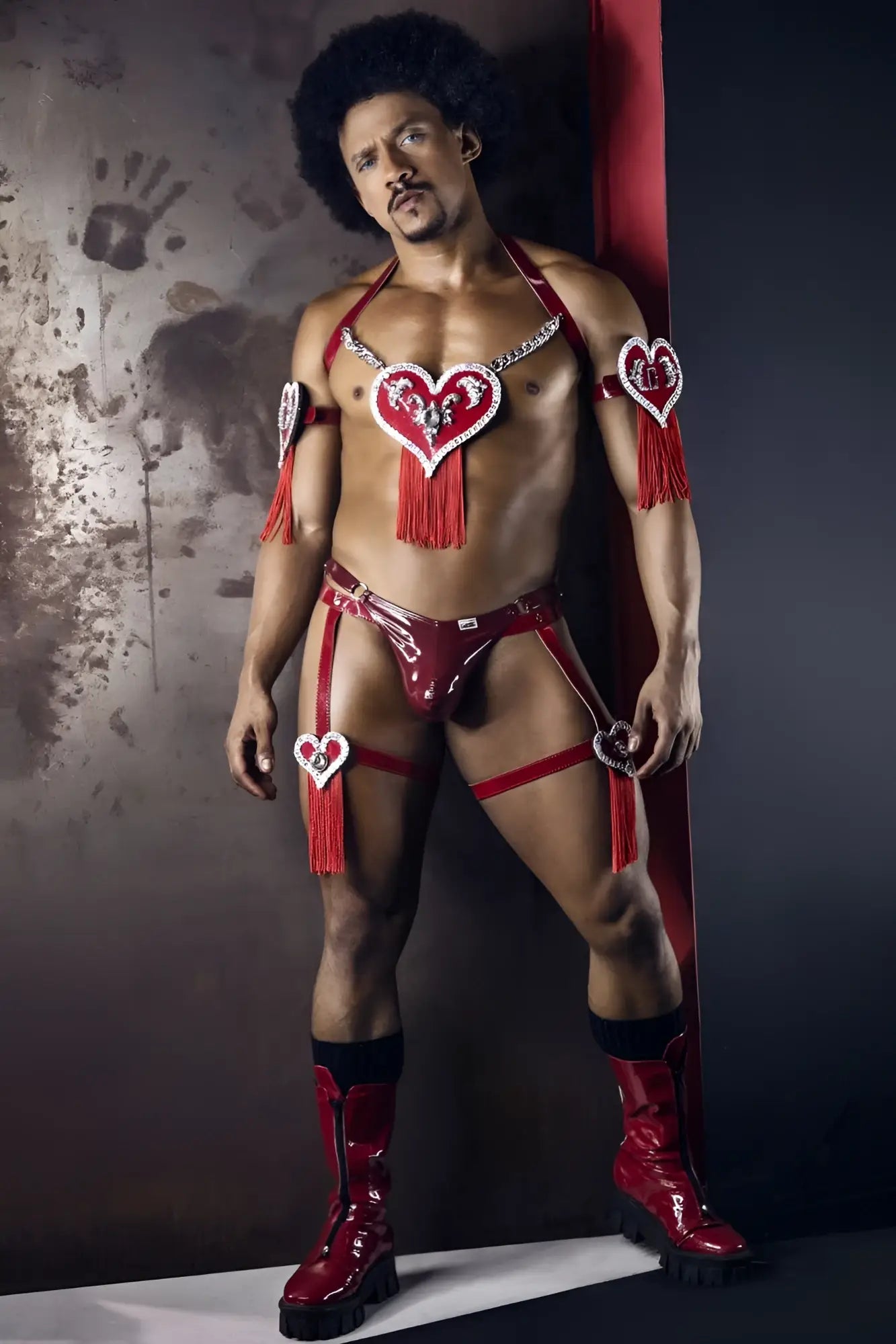 Red shiny latex dom thong with heart-shaped embellishments and tassels in gloss wine color by candyman
