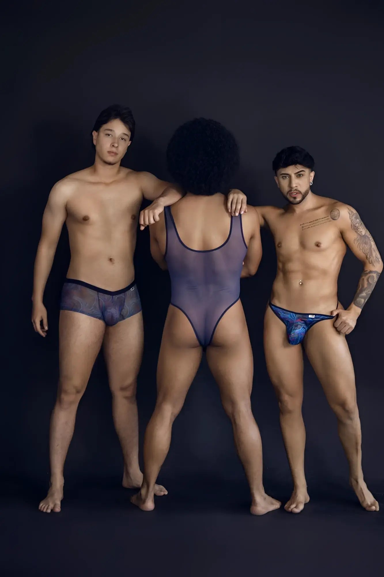 The central figure wears a sheer dark purple one-piece bodysuit with black trim in candyman 99875 seawater thongs multicolor print