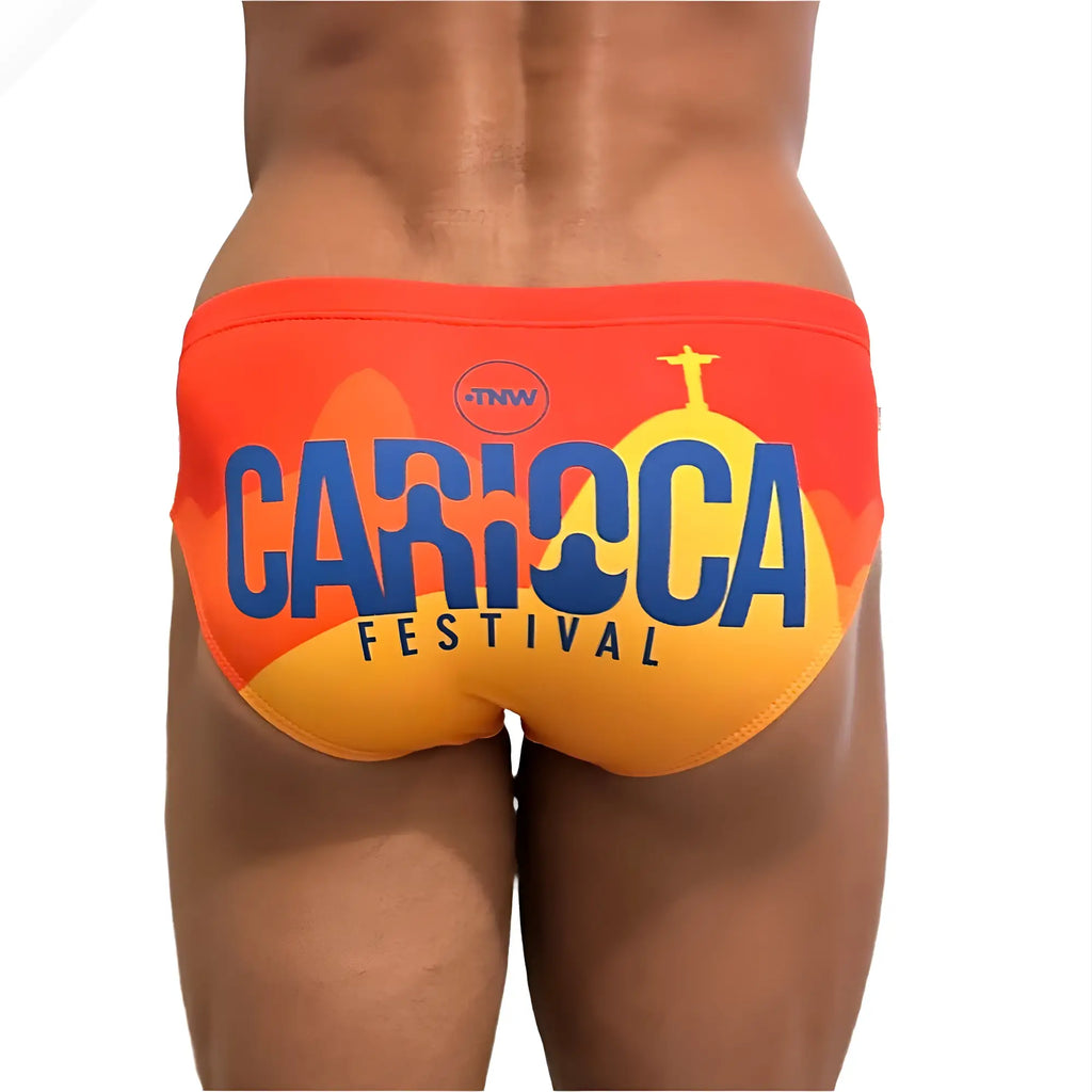 Vibrant orange and yellow swim trunks with bold blue carioca festival lettering and Christ the Redeemer silhouette