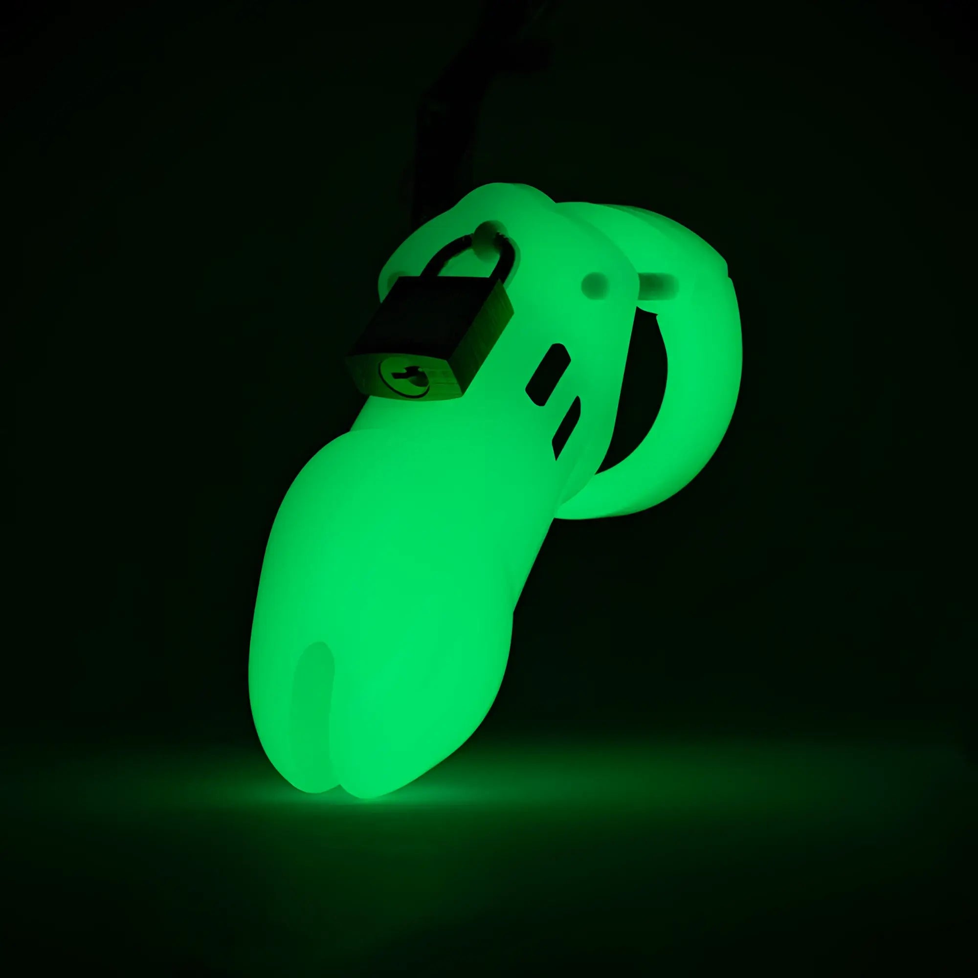 CB-X CB-6000 glow-in-the-dark green chastity cage with a metal padlock, set against a dark background.