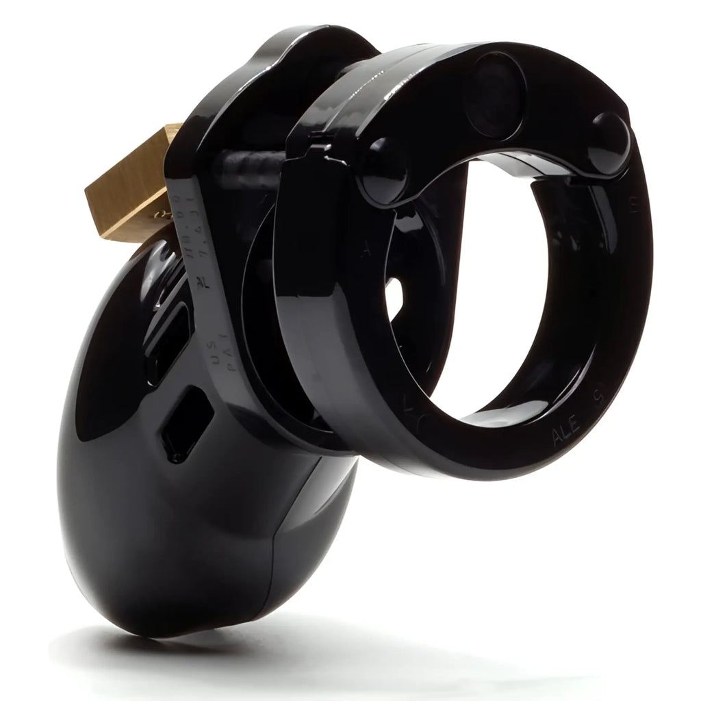 CB-X CB6000S black chastity cage kit featuring a glossy, vented plastic penis cage and a secure ring with brass lock.
