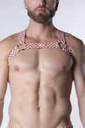 A man wearing a vibrant pulse elastic harness with geometric pink green and white zigzag stripes visible from the back