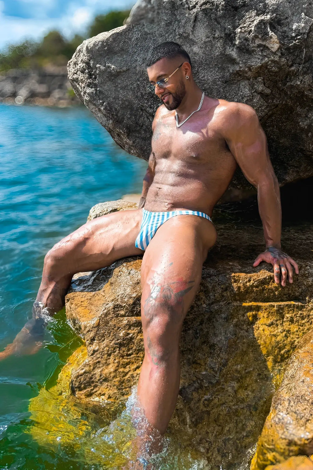 Cheeky classic g-string thong swim trunks with blue and white stripes displayed from the back side