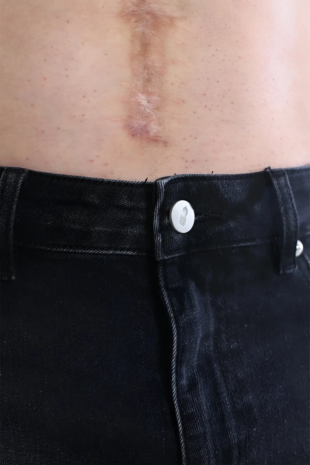 A subtle pineapple design white button fastened on dark denim cheeky summer 2.5 inch brief shorts black