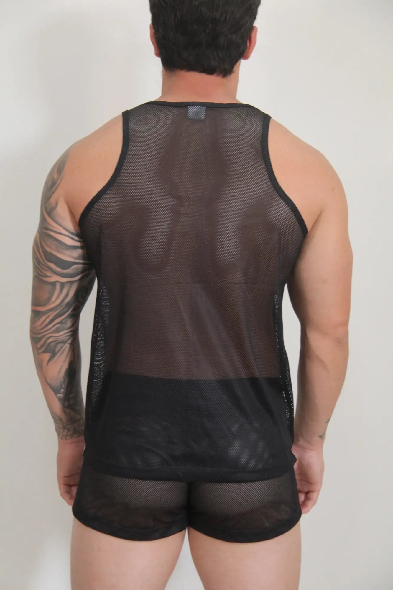 Black mesh tank top with solid black band at the bottom from circuit mesh tanks available in four colors