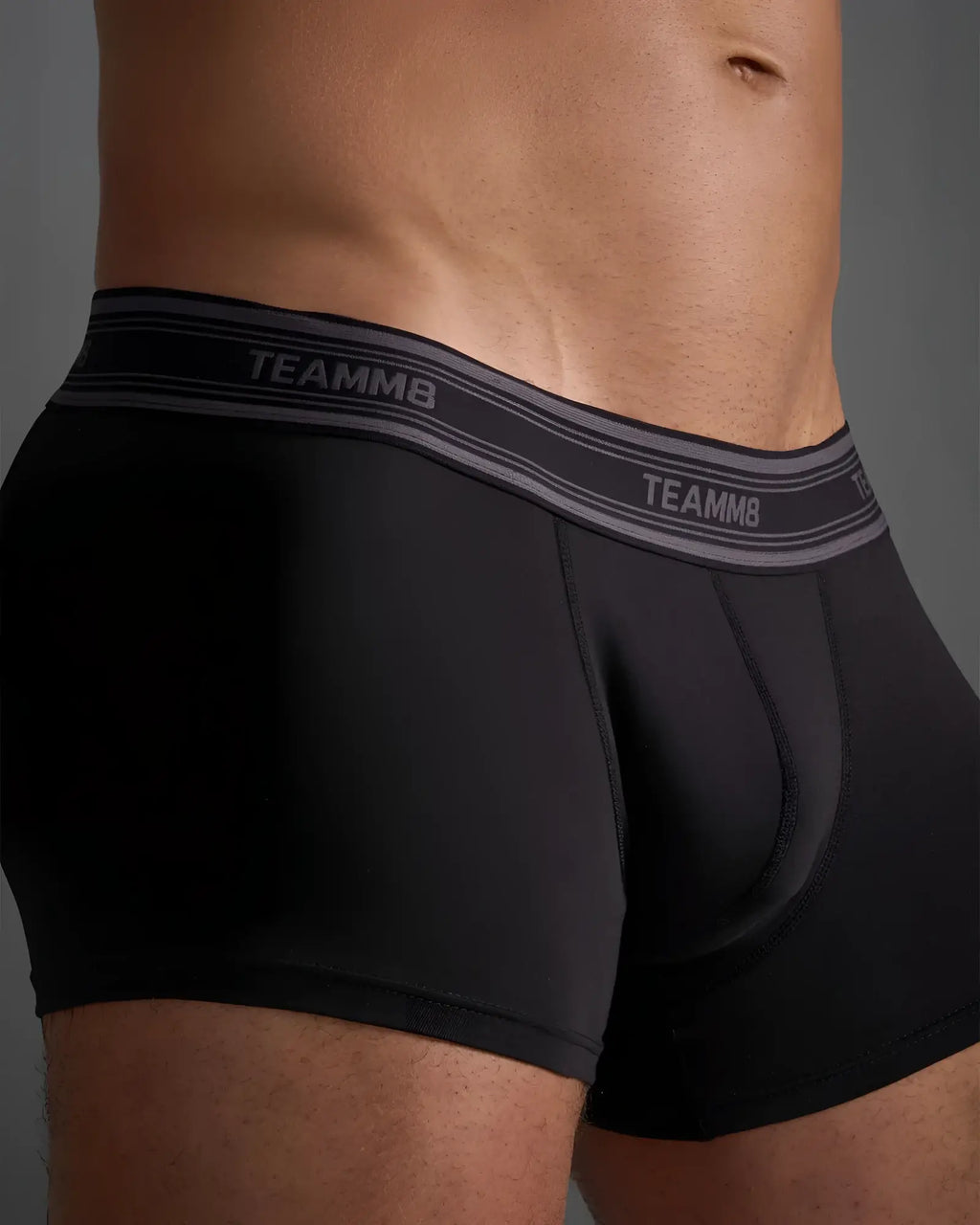 Black classic cotton trunk briefs with gray elastic waistband and white brand name lettering on front side