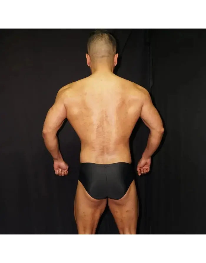 Black bodybuilding posing suit shown on a male model from the back highlighting the fit and design by Arroyman.