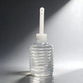 CleanStream disposable enema applicator: a clear, ribbed plastic squeeze bulb with a long, thin white nozzle.