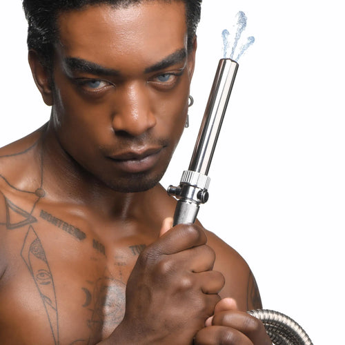 CleanStream Enema Nozzle, a silver stainless steel nozzle with shut-off valve, spraying water, held by a shirtless man.