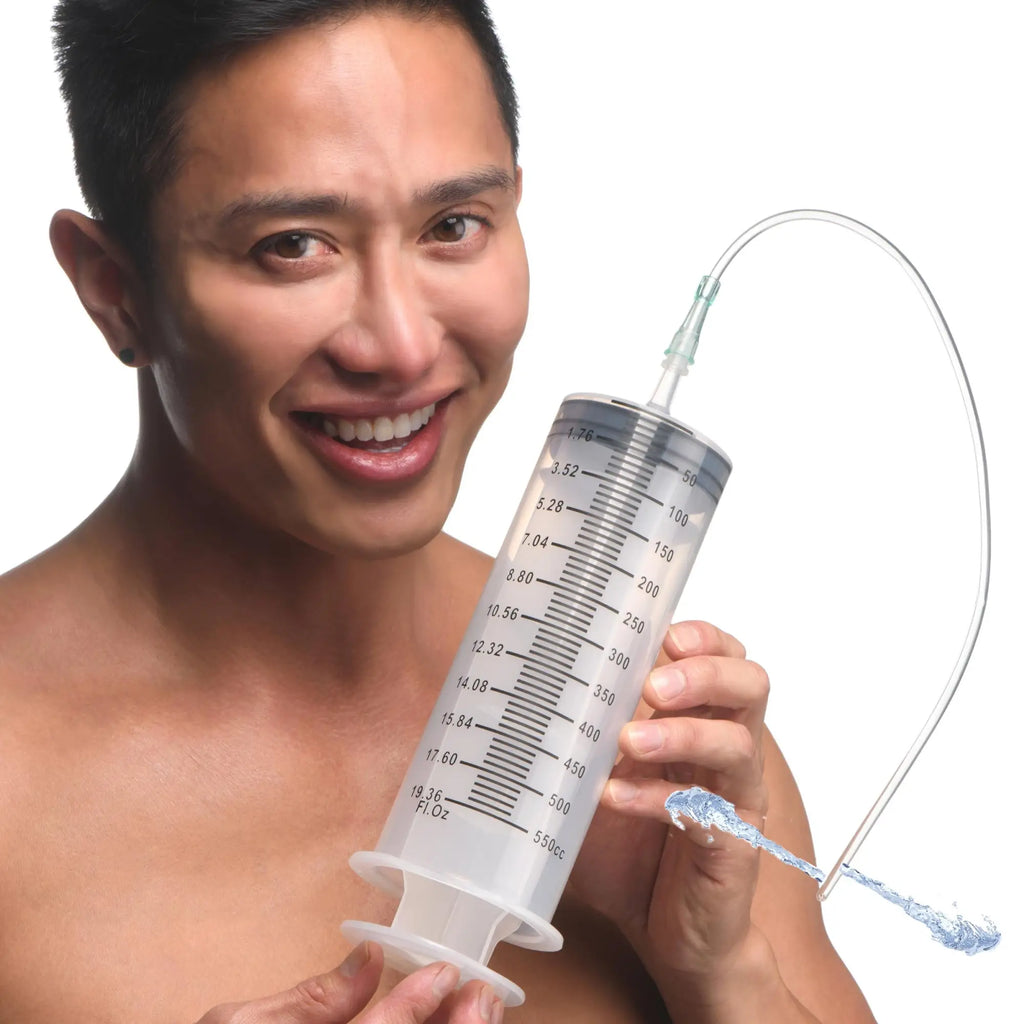 A man holds a large, translucent CleanStream Enema Syringe with measurement markings and a clear attached tube.