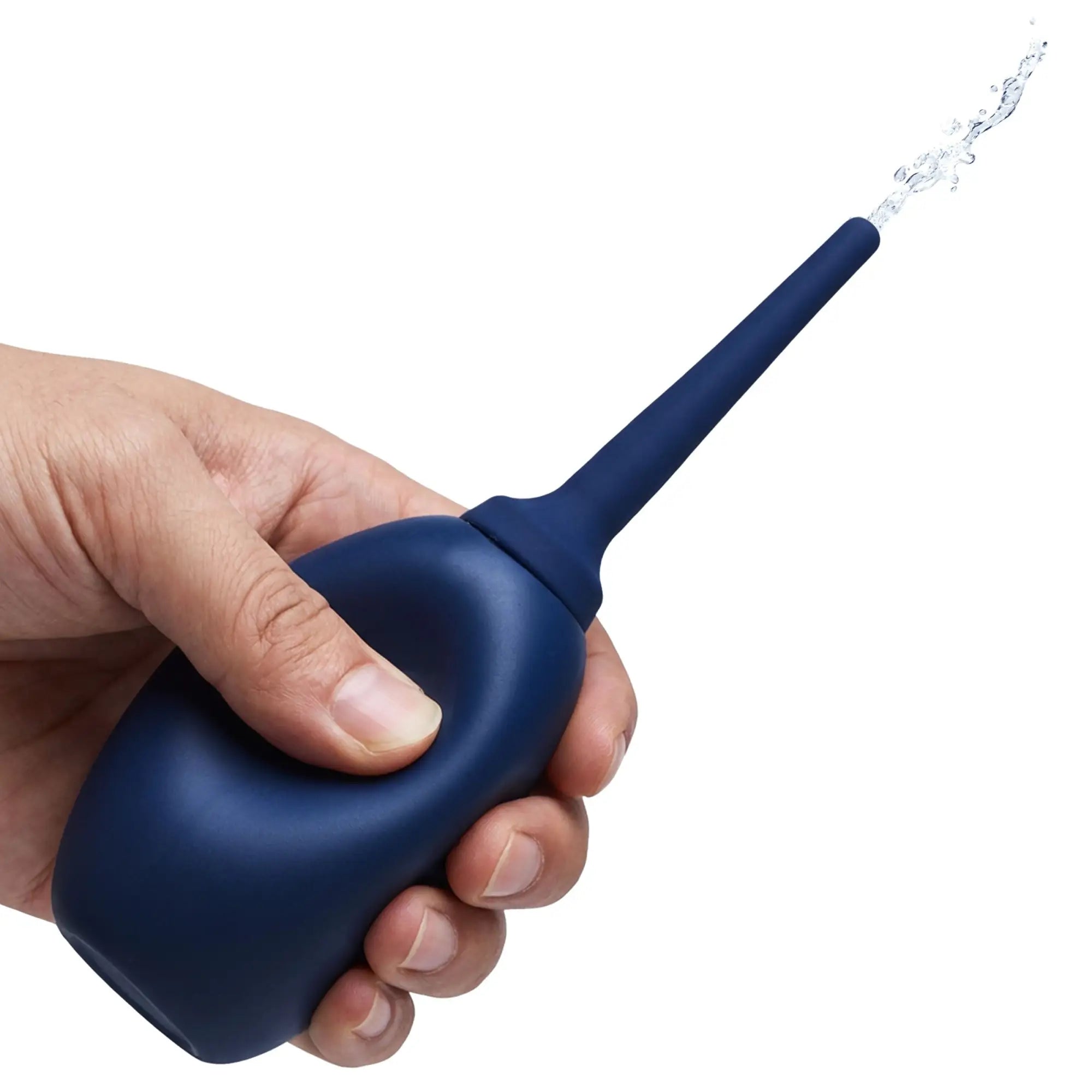 A hand squeezing a navy blue CleanStream Flex Tip enema bulb, with a stream of water spraying from the tip.
