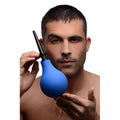 A shirtless man holds a blue CleanStream Premium one-way valve anal douche with a black nozzle.