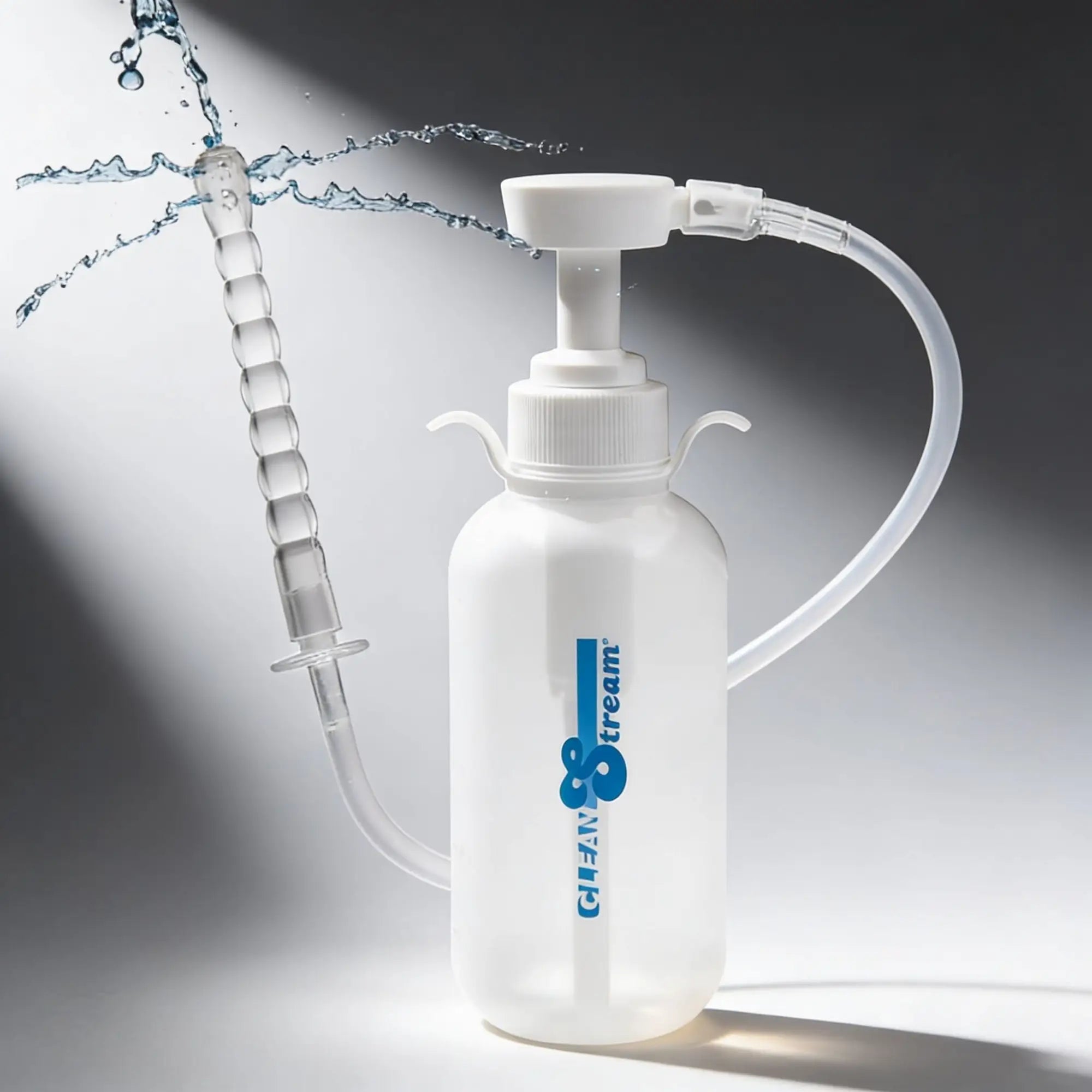 CleanStream pump enema bottle: a translucent white bottle with a ribbed nozzle spraying water, on a gray background.