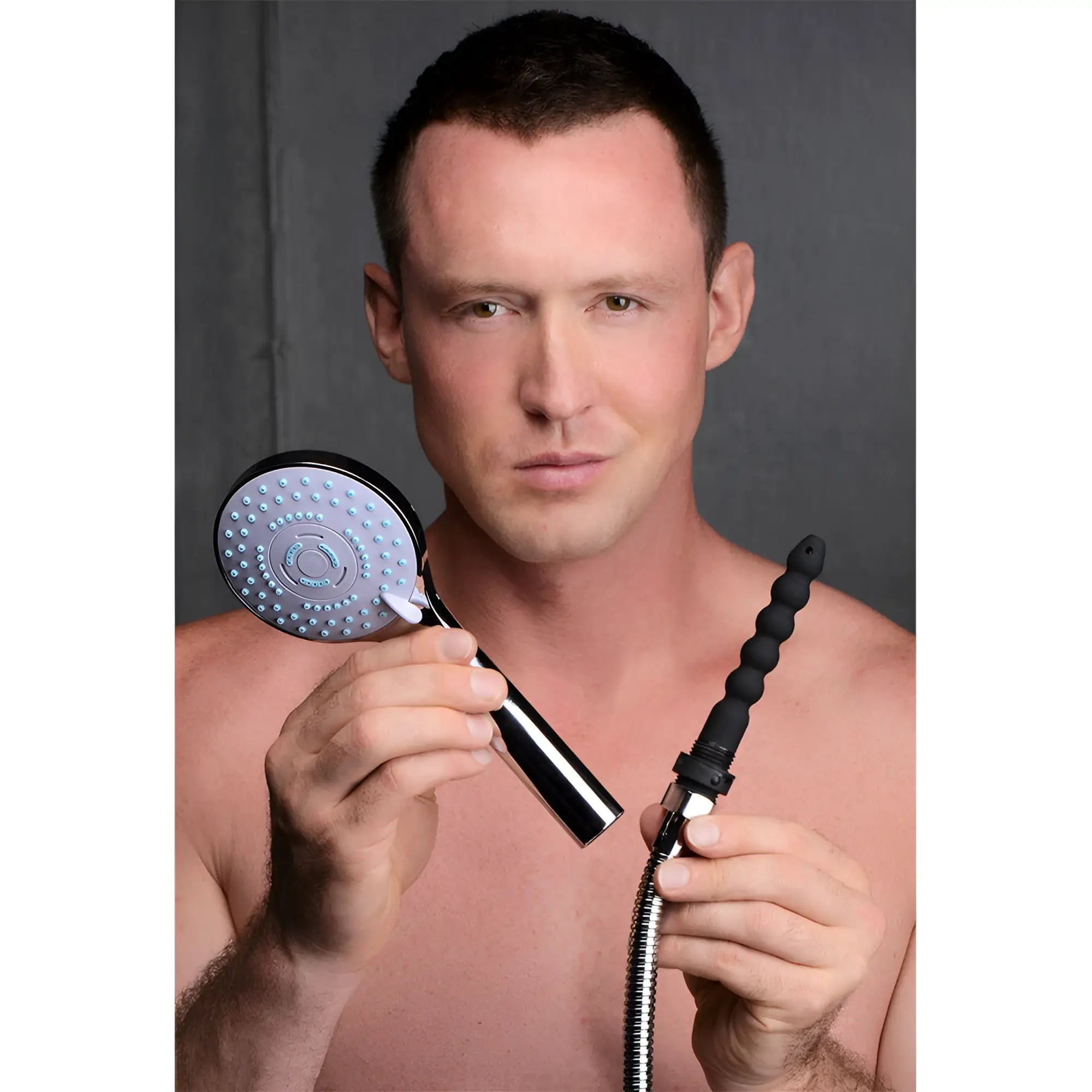 A man holds a chrome CleanStream shower head and a flexible black silicone attachment connected to a metal hose.