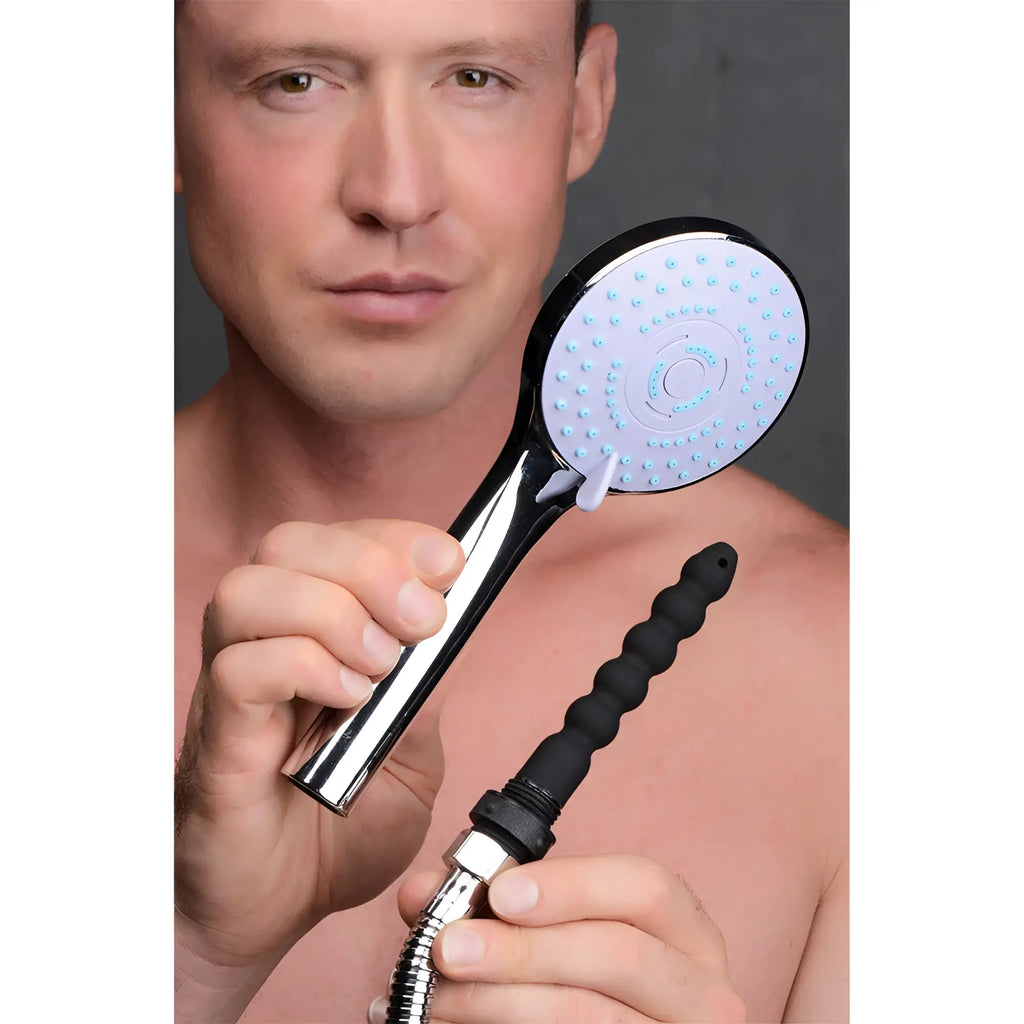 CleanStream Shower Head with a round chrome face and a separate black silicone nozzle attachment held by a man.
