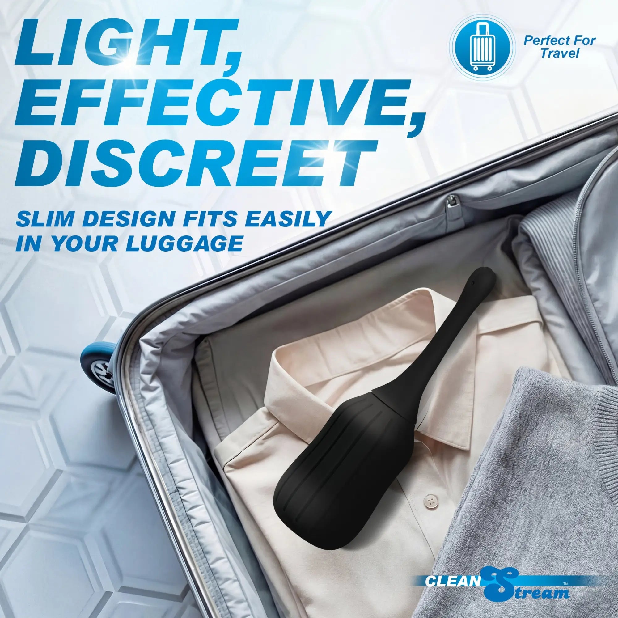 CleanStream black silicone enema bulb with poseable nozzle rests inside an open suitcase on top of folded clothes.